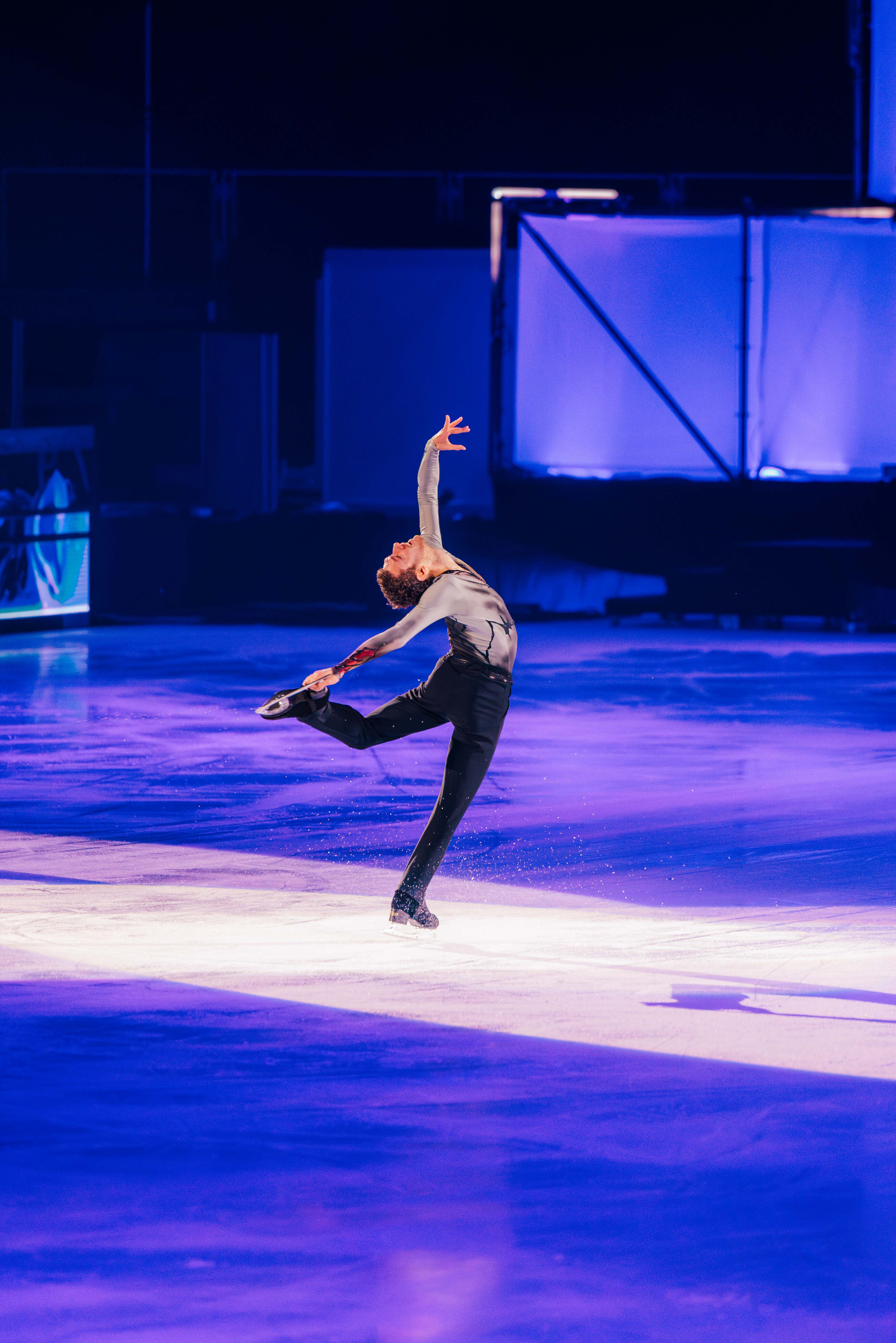 Solokünstler auf dem Eis in ausdrucksstarker Pose im Scheinwerferlicht