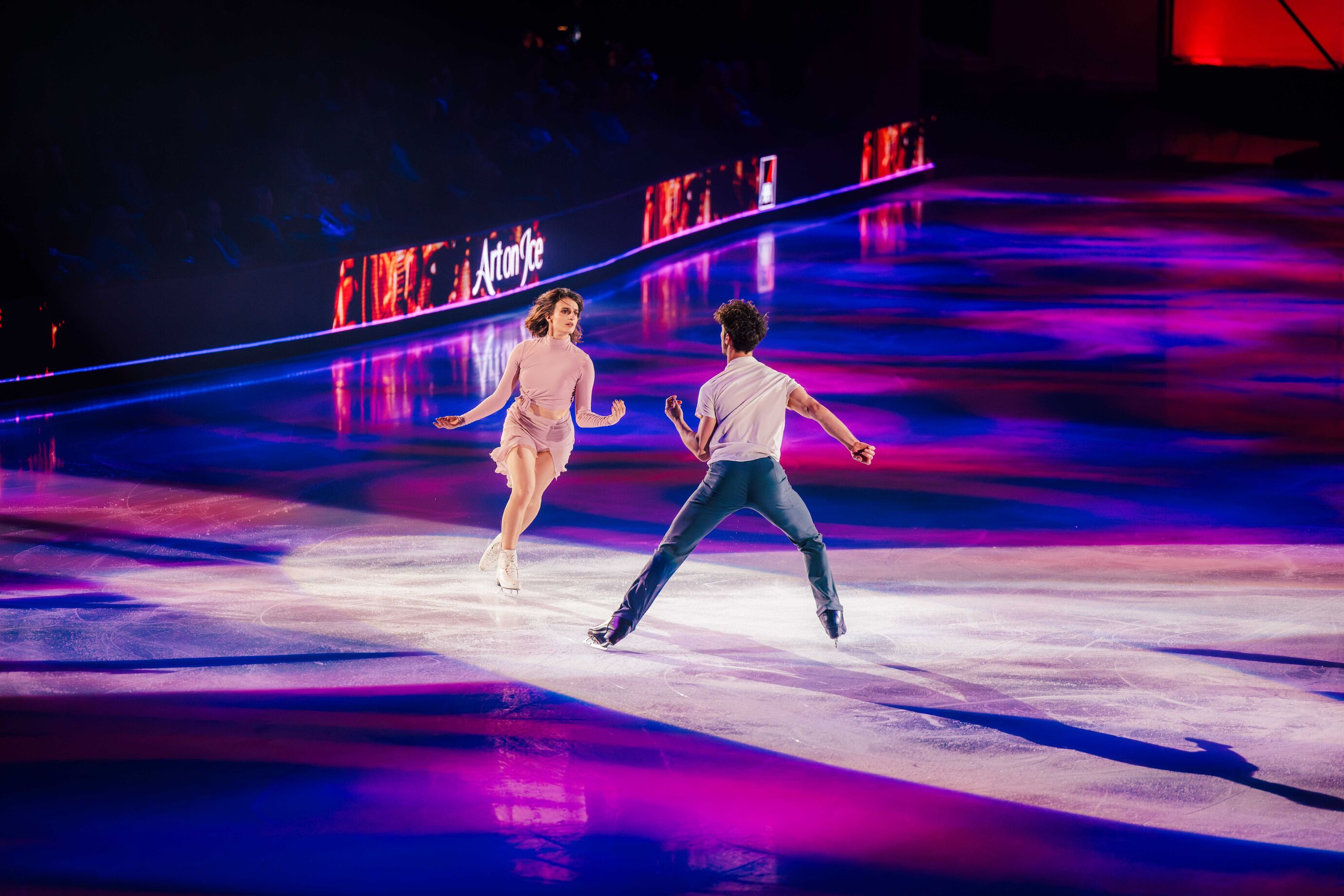 Eistanzpaar in schneller Choreografie auf der Eisfläche