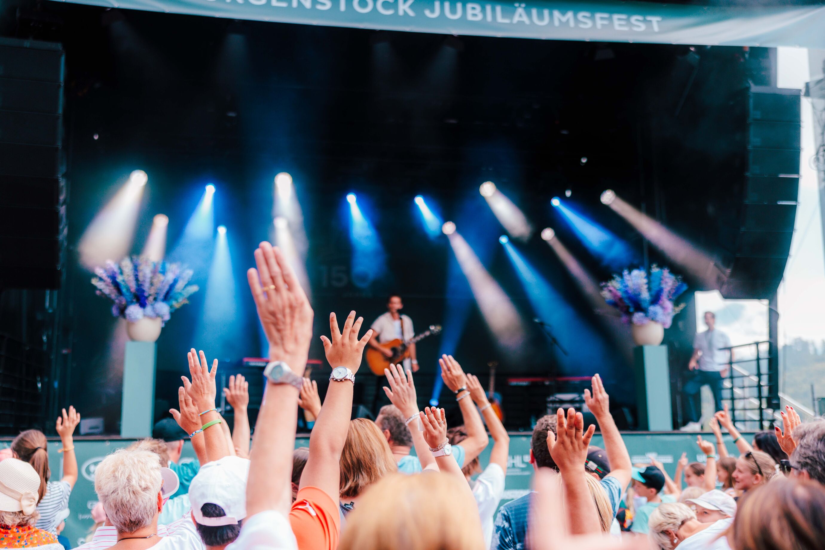Besucher reissen die Hände in die Luft beim Konzert am Bürgenstock Jubiläumsfest
