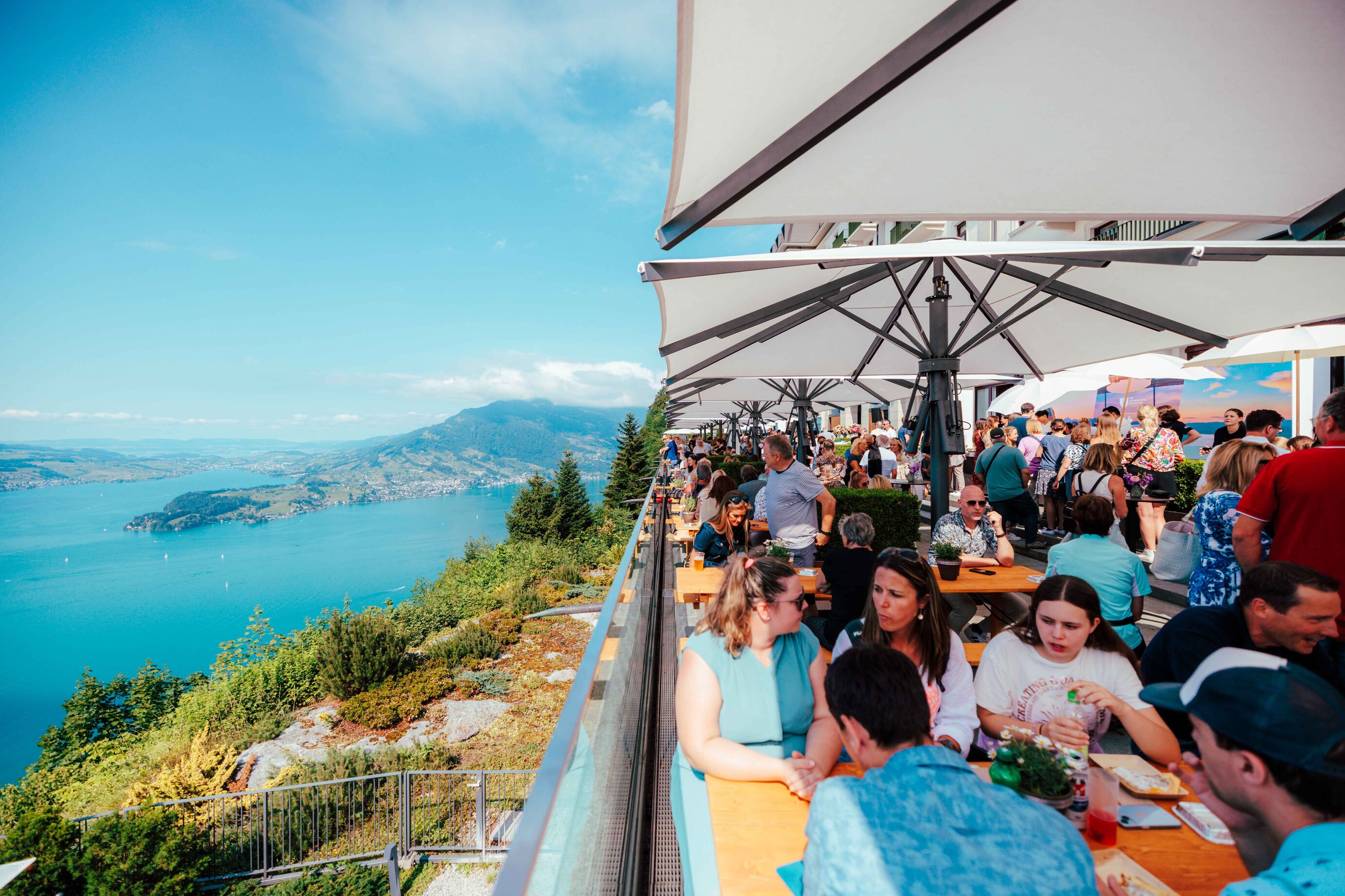 Gäste feiern auf der Terrasse mit Blick auf den Vierwaldstättersee beim Jubiläum