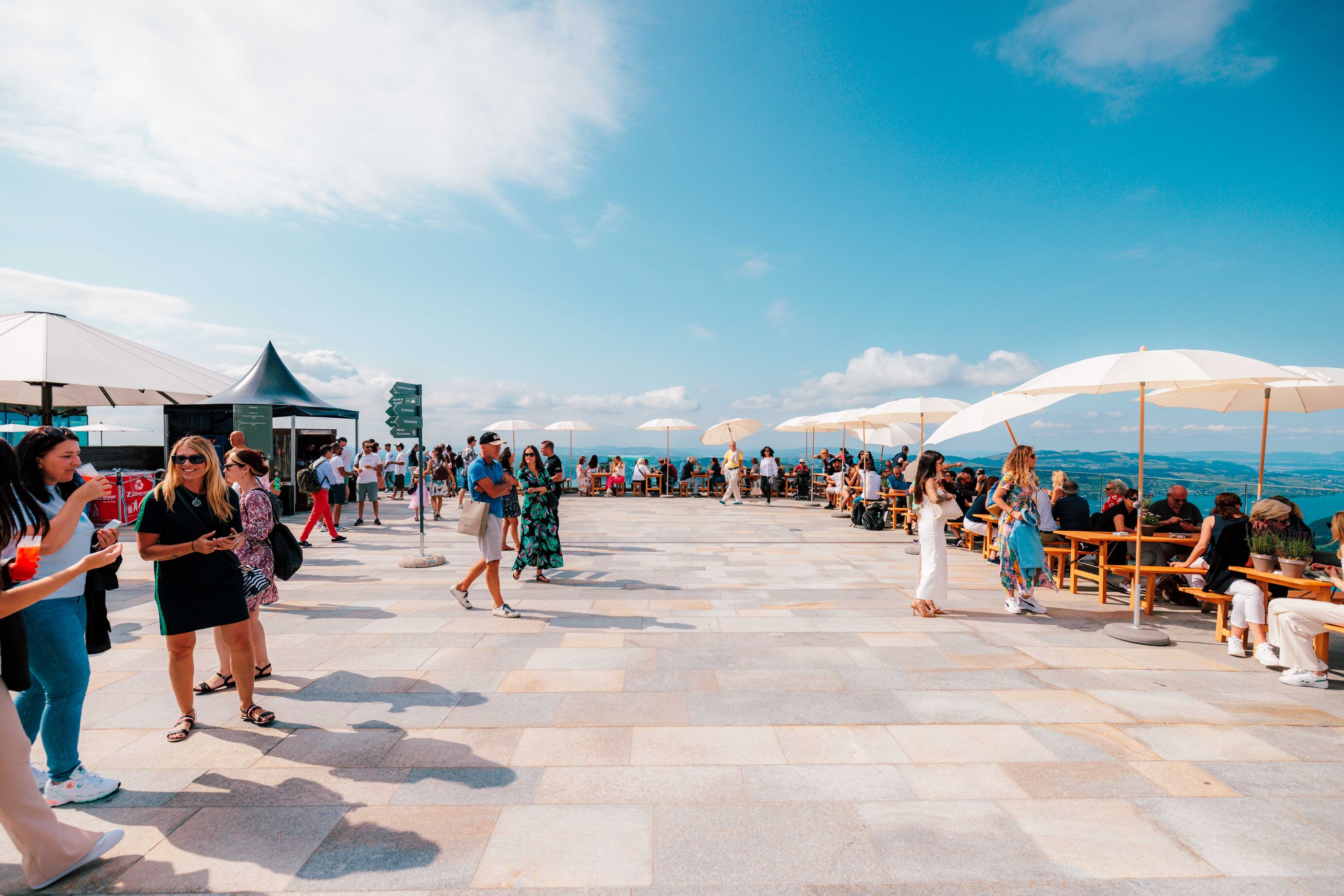 Besucher geniessen die Aussicht und das Fest auf der Terrasse am Bürgenstock