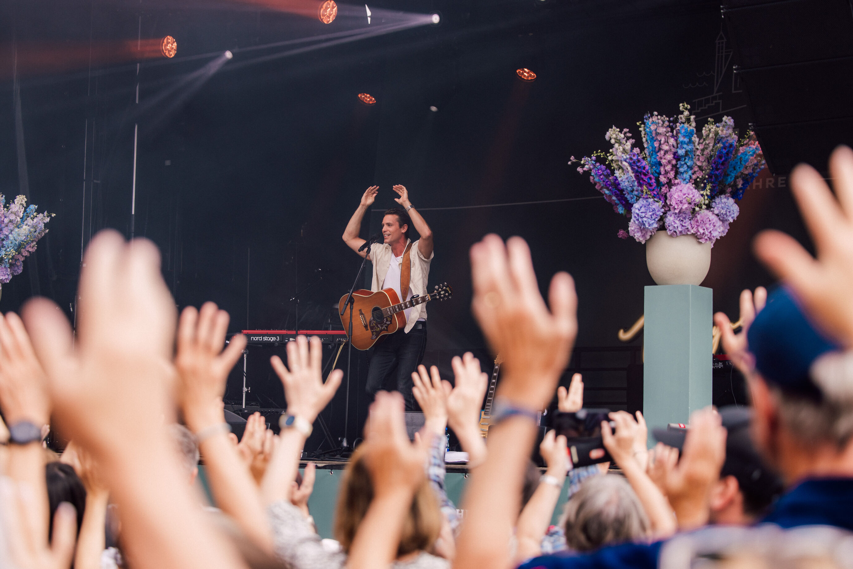 Hände im Publikum jubeln bei einer Performance am Jubiläum Bürgenstock