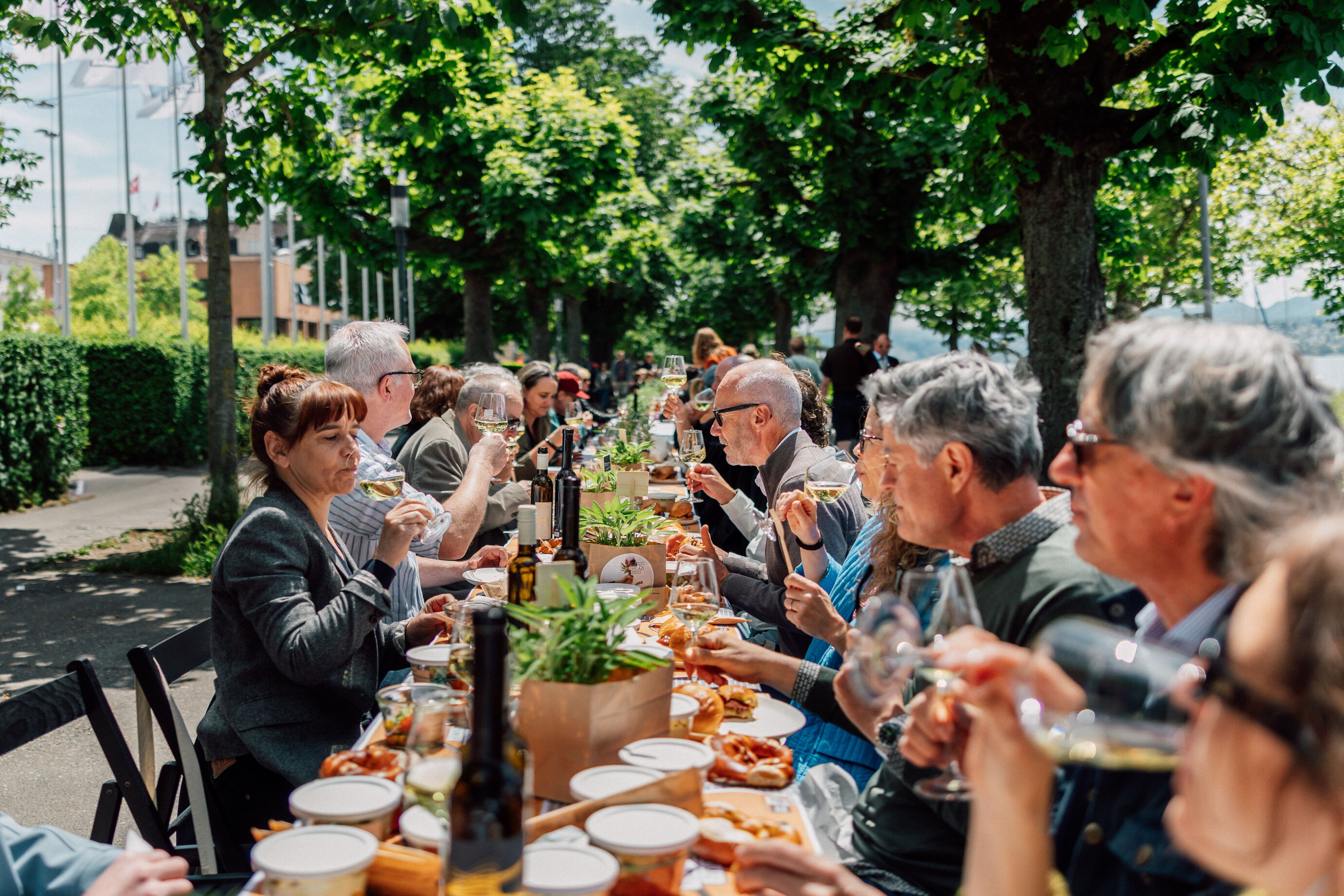 Menschen sitzen an einer langen Tafel und geniessen Essen beim Food Festival Zürich