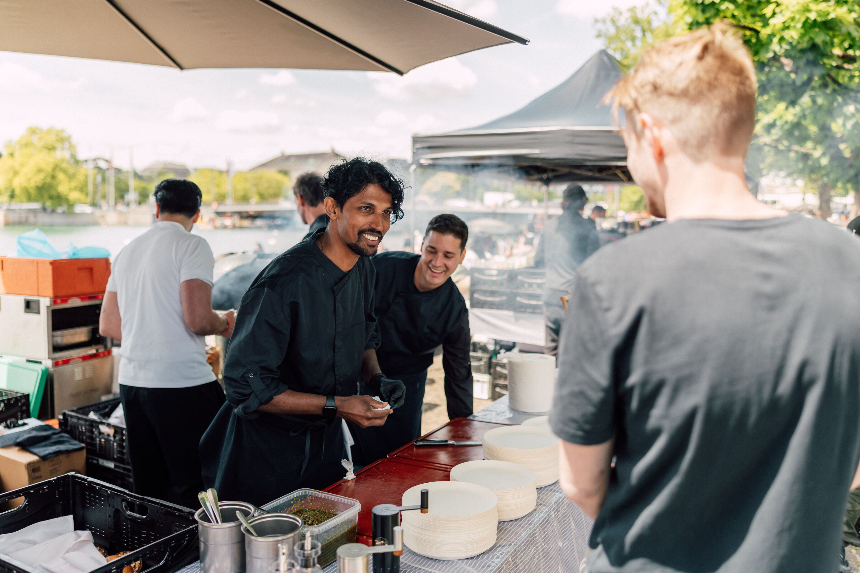 Köche bereiten Essen zu und sprechen mit Gästen beim Food Festival Zürich