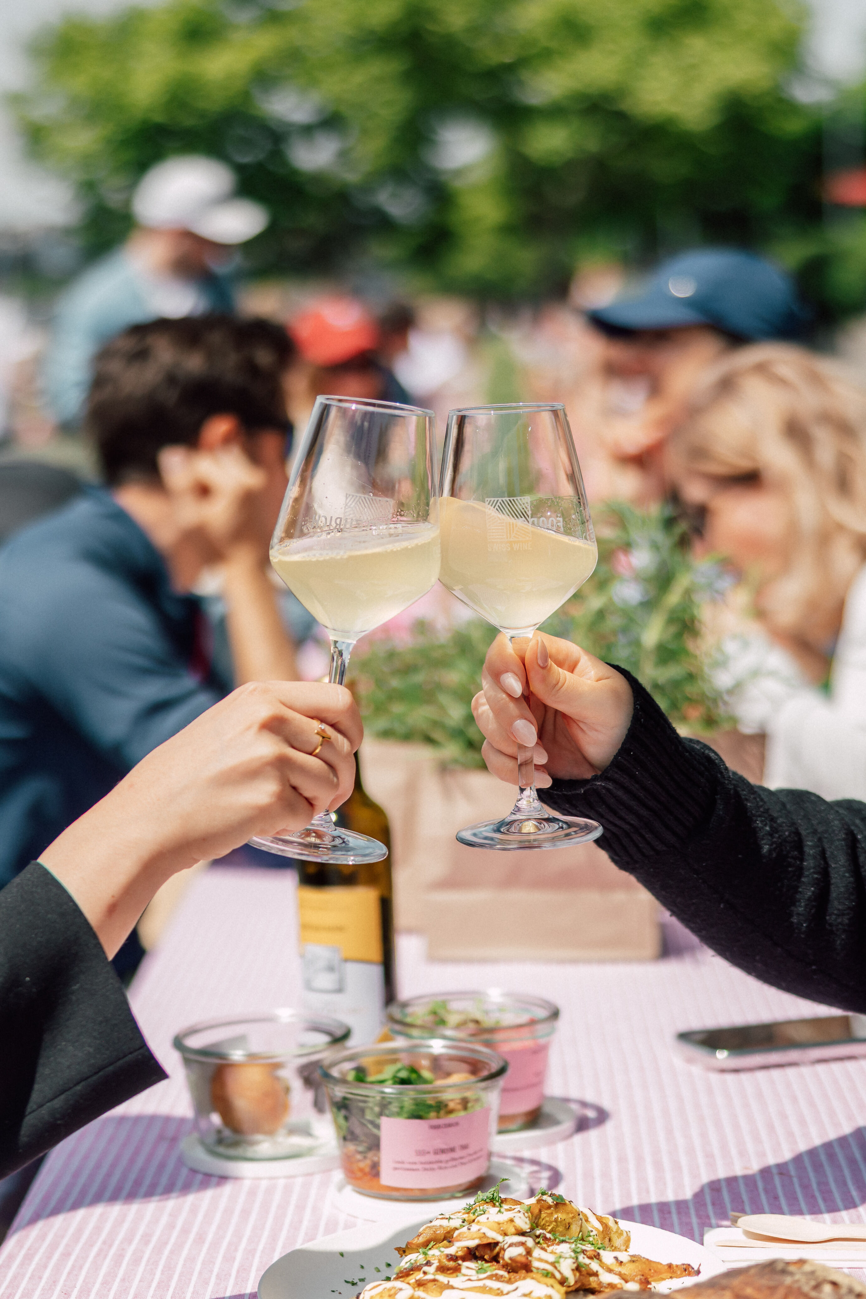 Paar stösst mit Weingläsern am Food Festival Zürich an