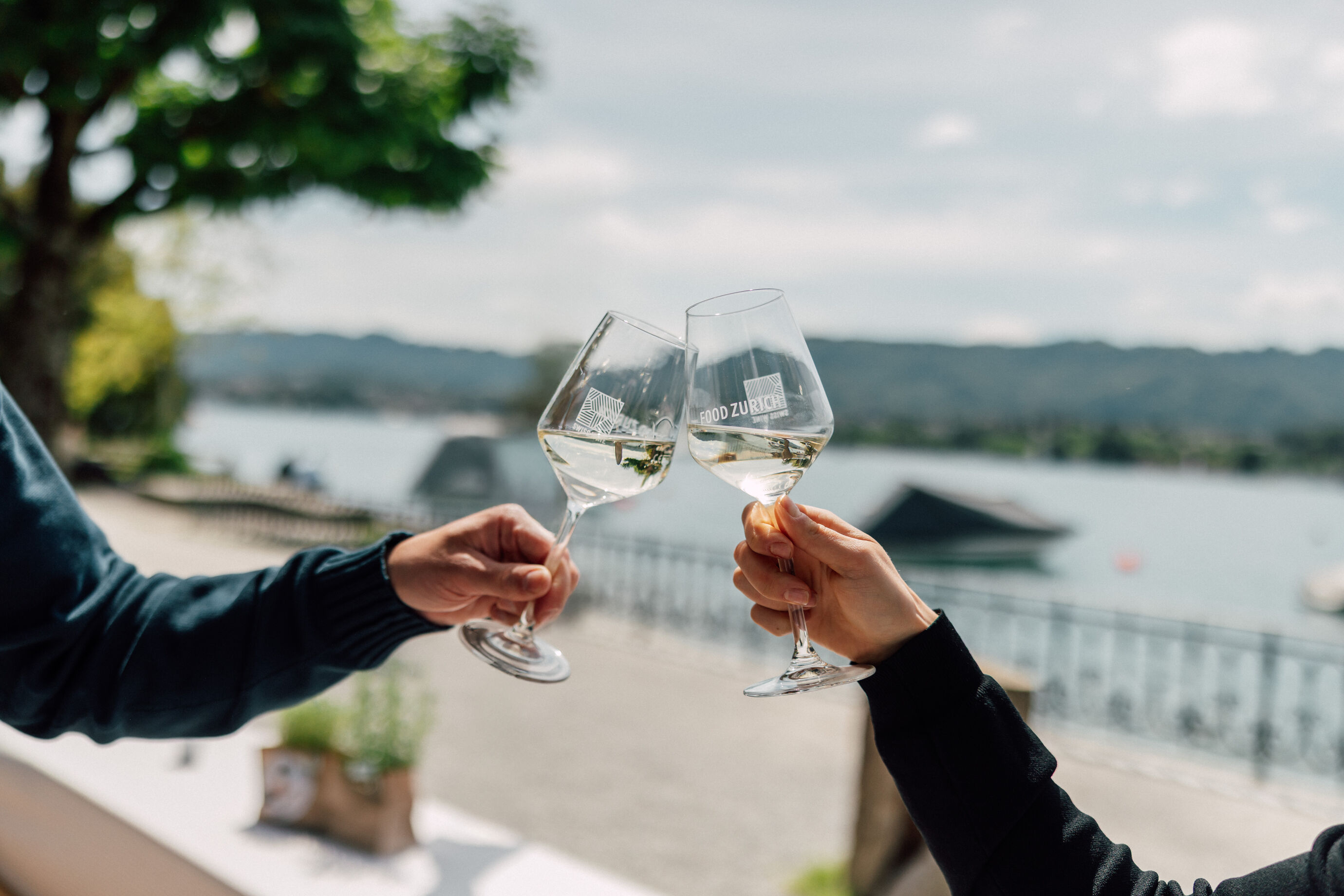 Zwei Gläser Weisswein beim Anstossen am Seeufer beim Food Festival Zürich