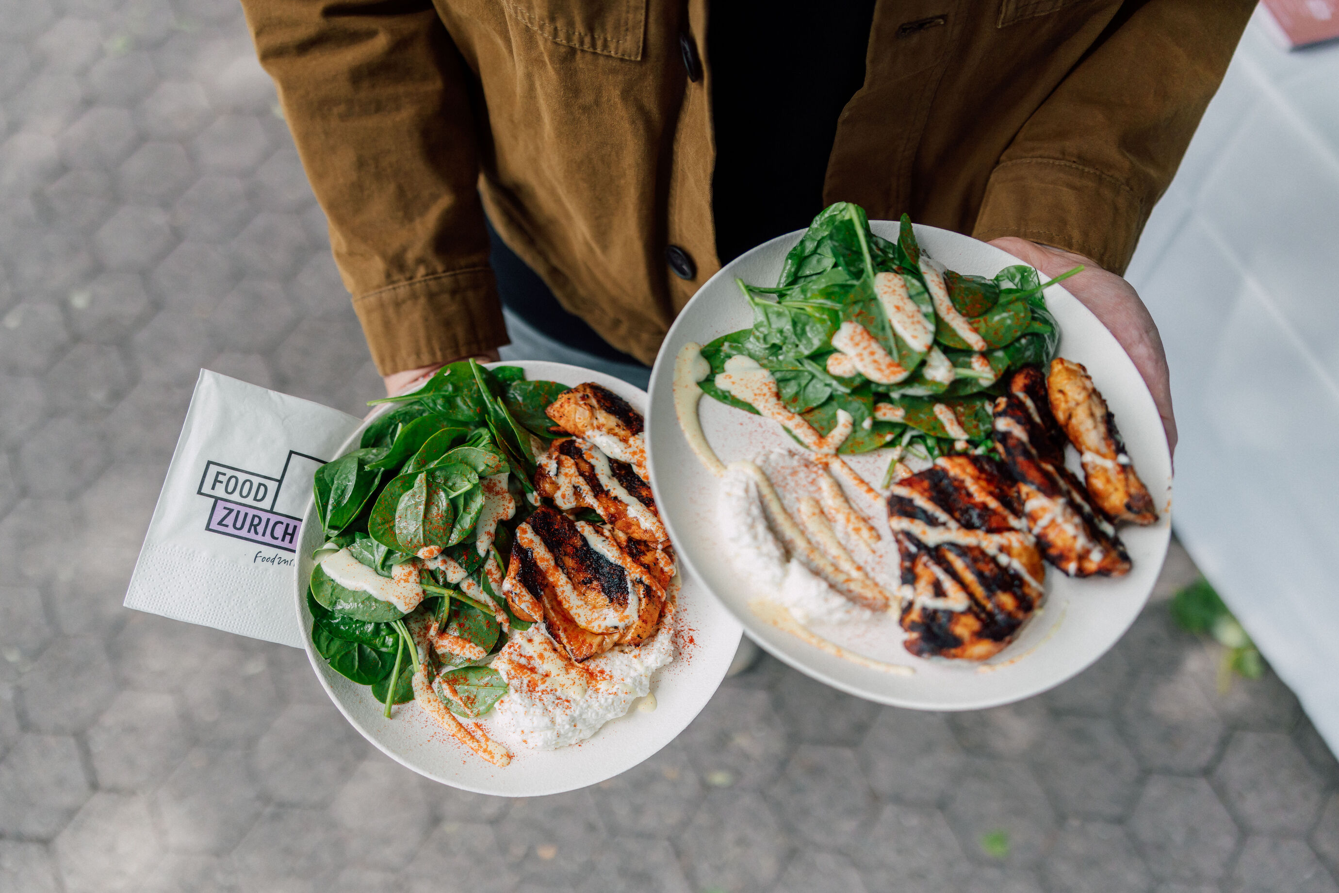 Zwei Teller mit gegrilltem Fleisch und Beilagen beim Food Festival Zürich