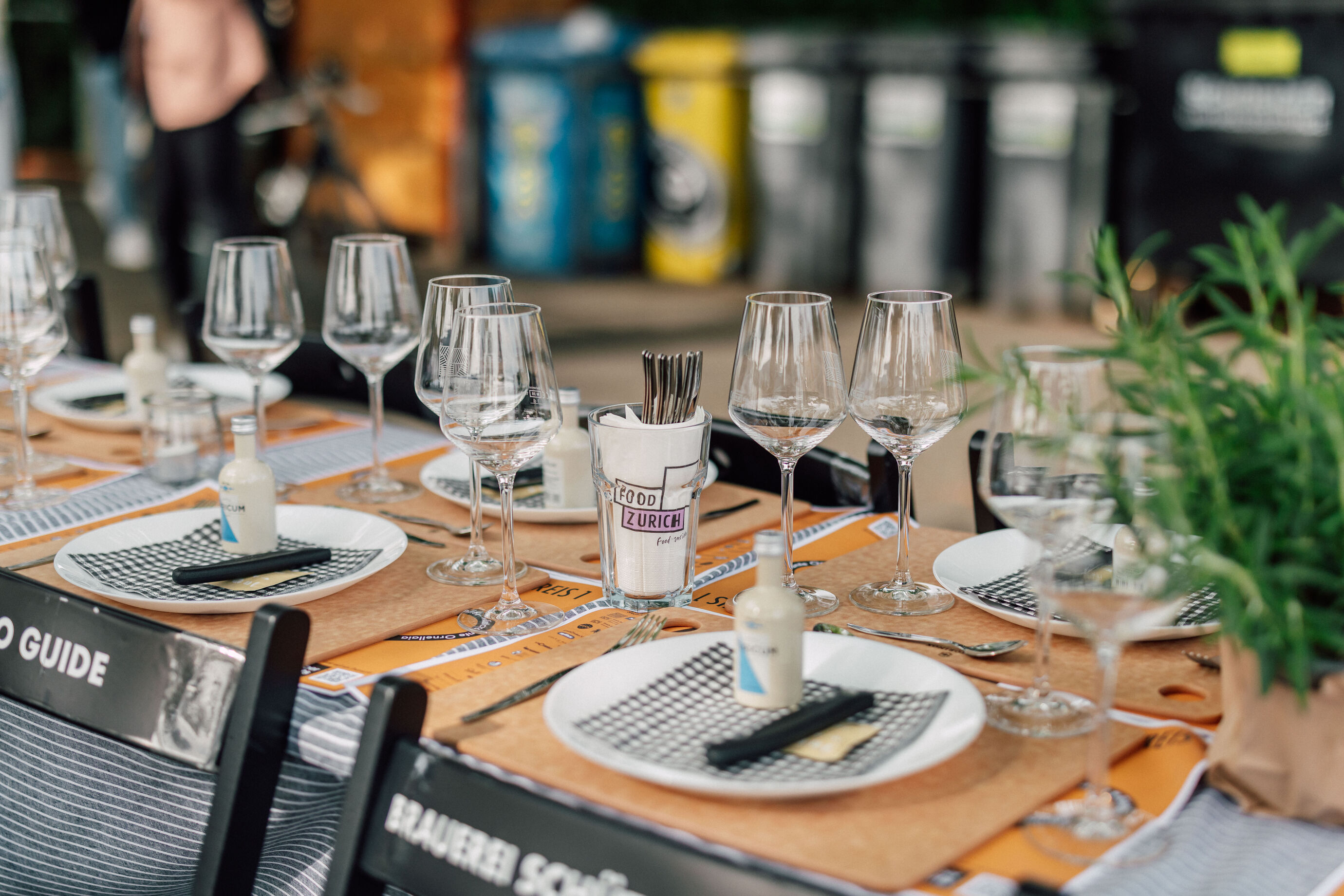 Elegant gedeckter Tisch mit Gläsern, Tellern und Kräuterdeko am Food Festival Zürich