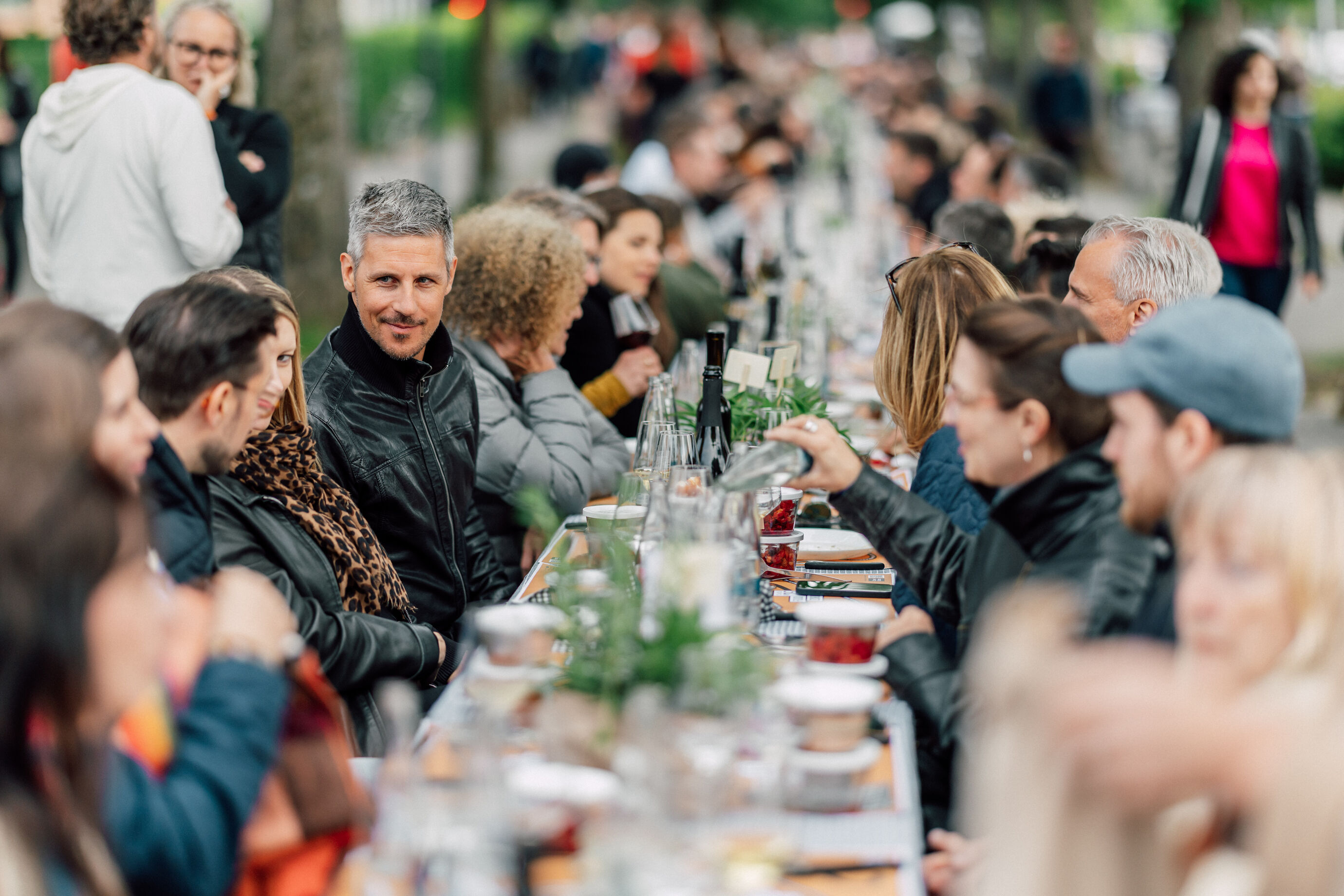 Menschen sitzen an langer Tafel beim Food Festival Zürich