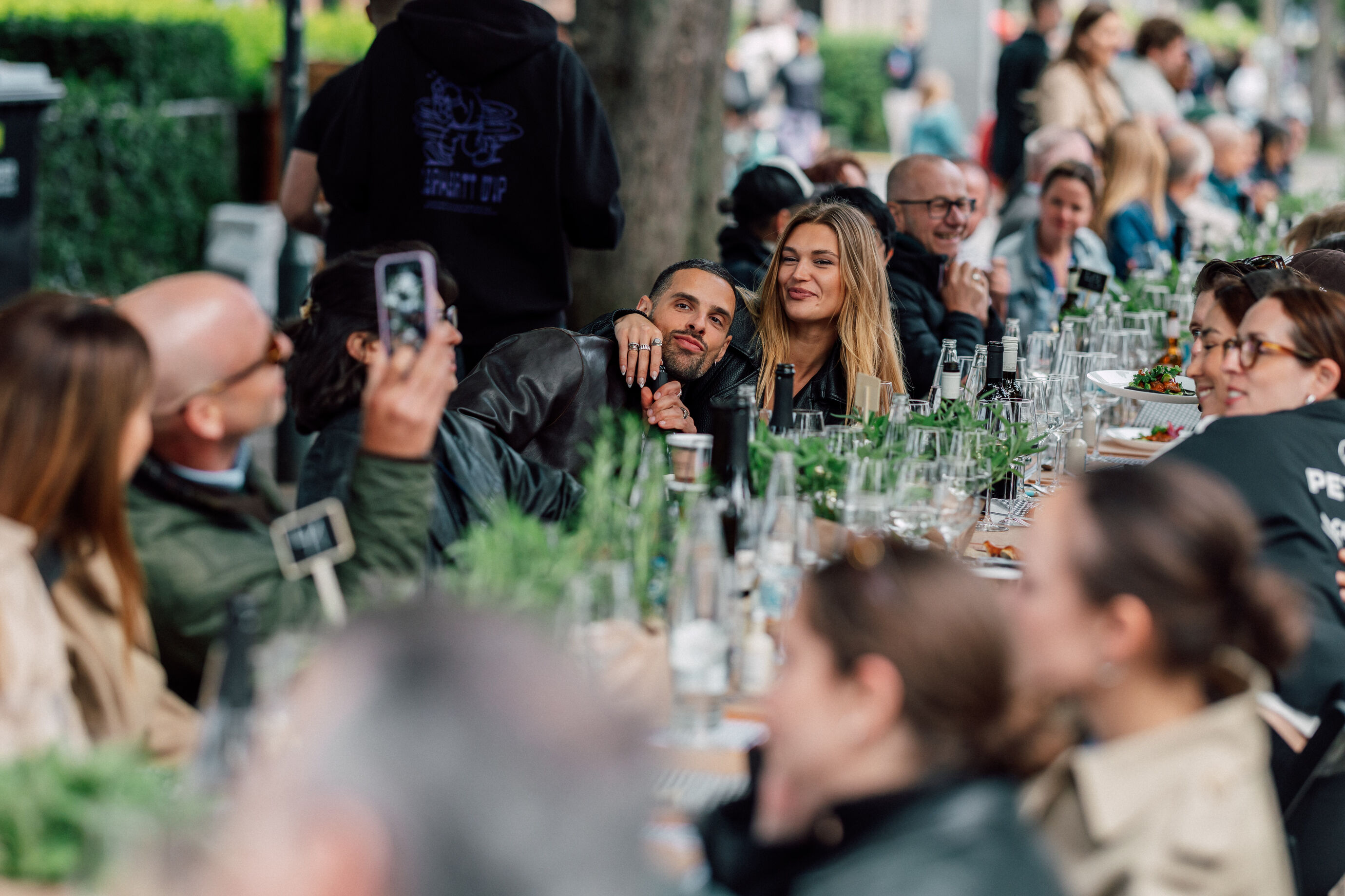 Frau wird beim Sitzen an langer Tafel am Food Festival Zürich fotografiert