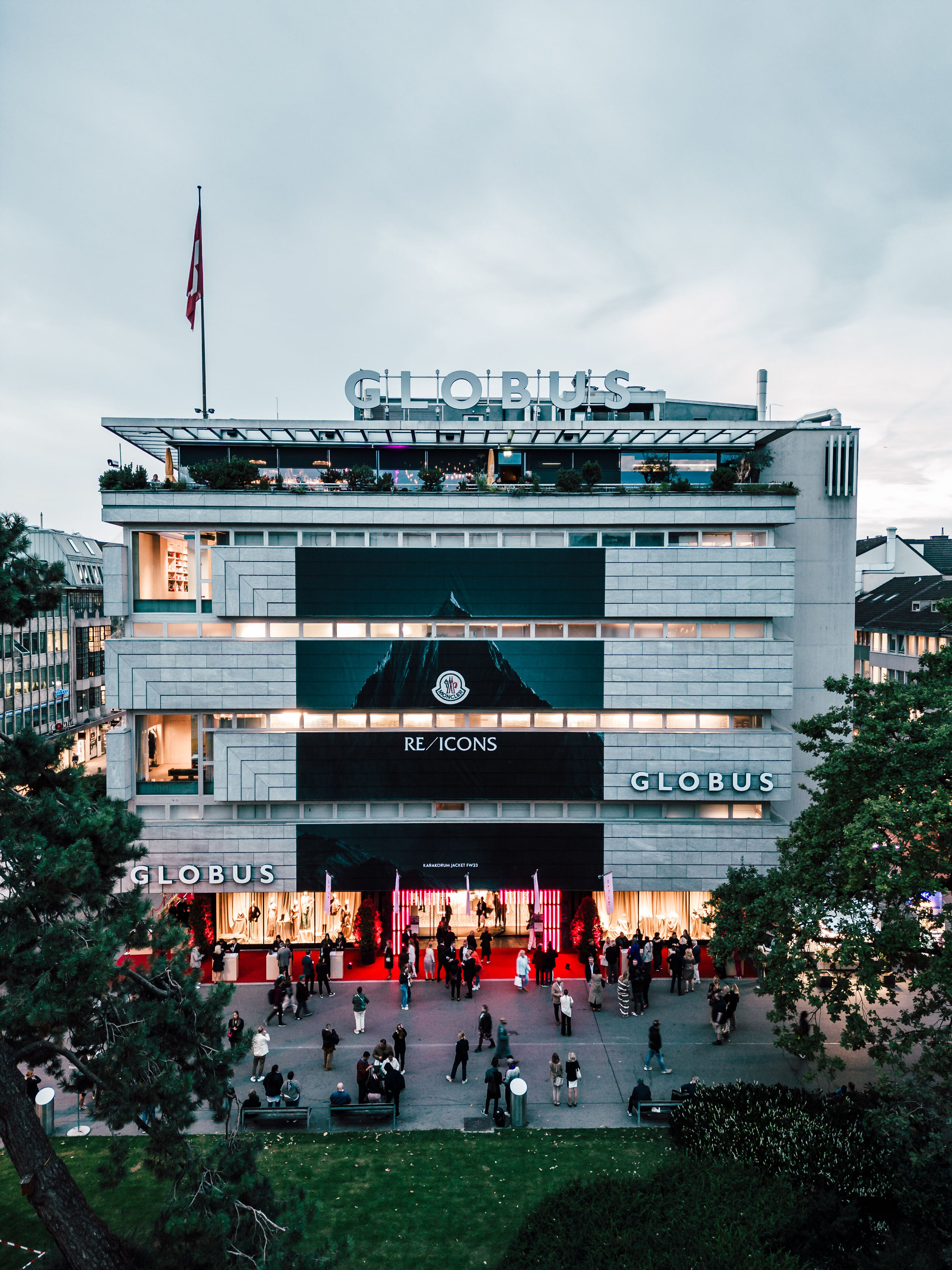 Aussenansicht des Globus Zürich mit feierlicher Eröffnung und rotem Teppich.