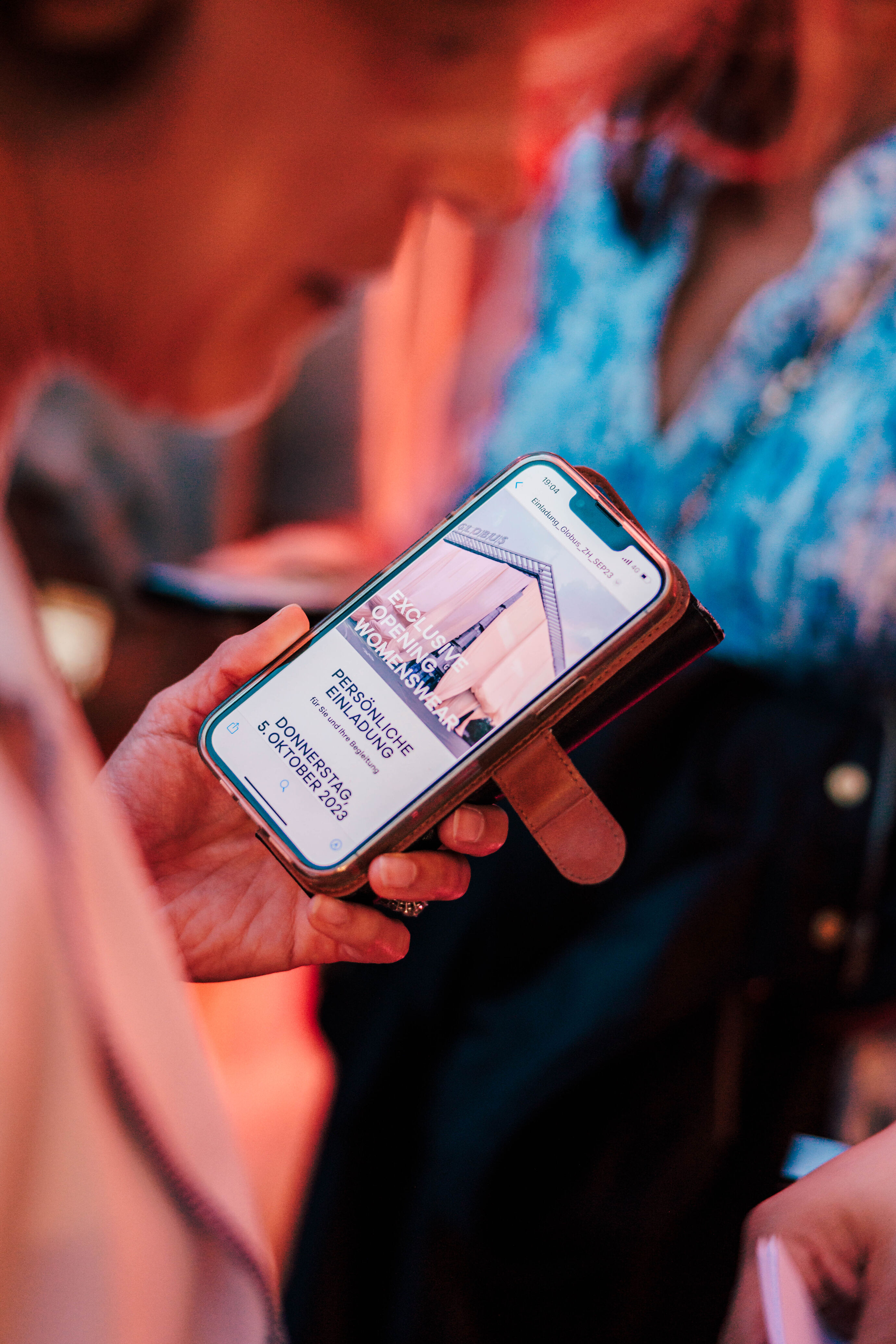 Detailaufnahme eines Smartphones mit der Einladung zum Globus Opening.