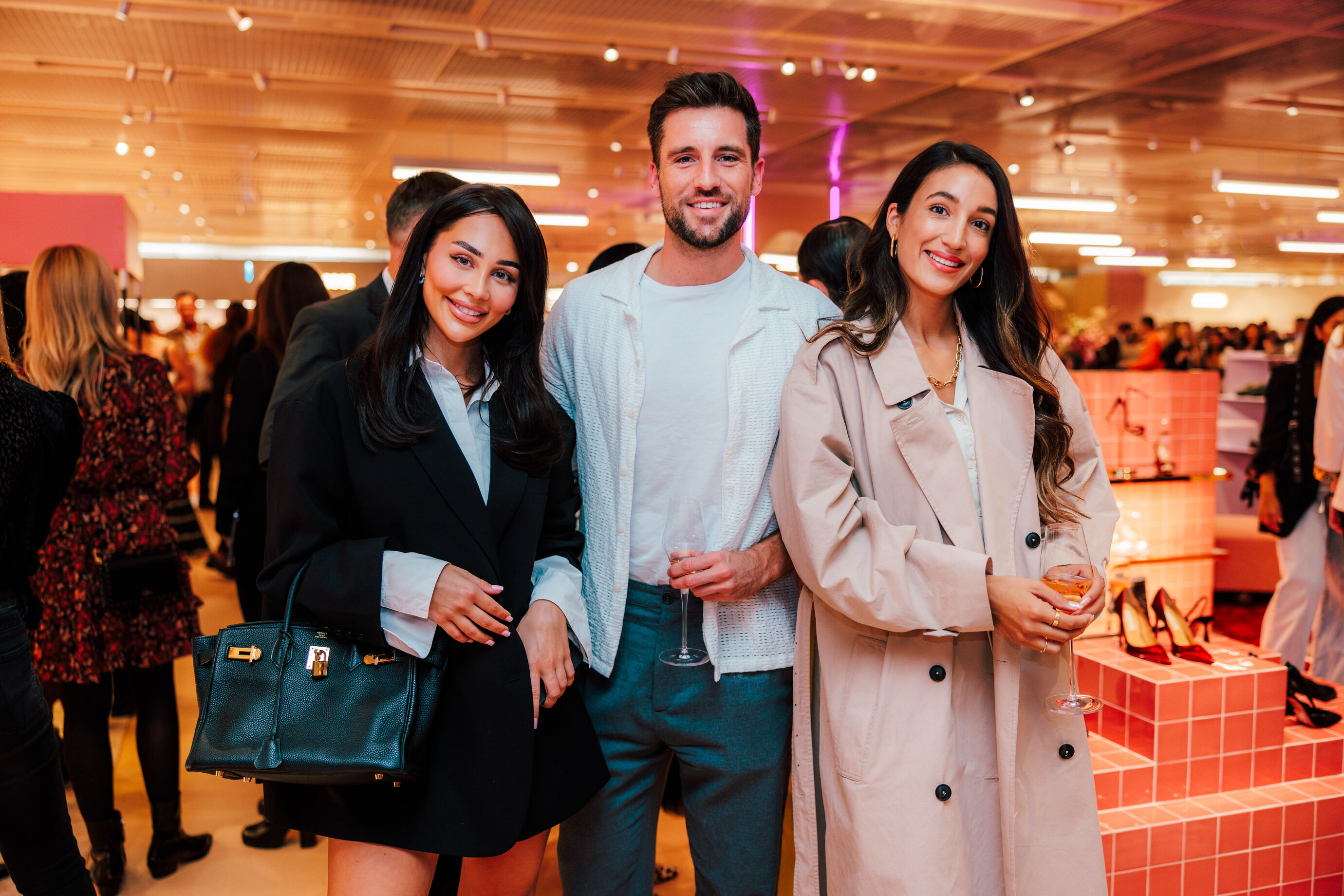 Zwei Frauen und ein Mann posieren beim Globus Opening