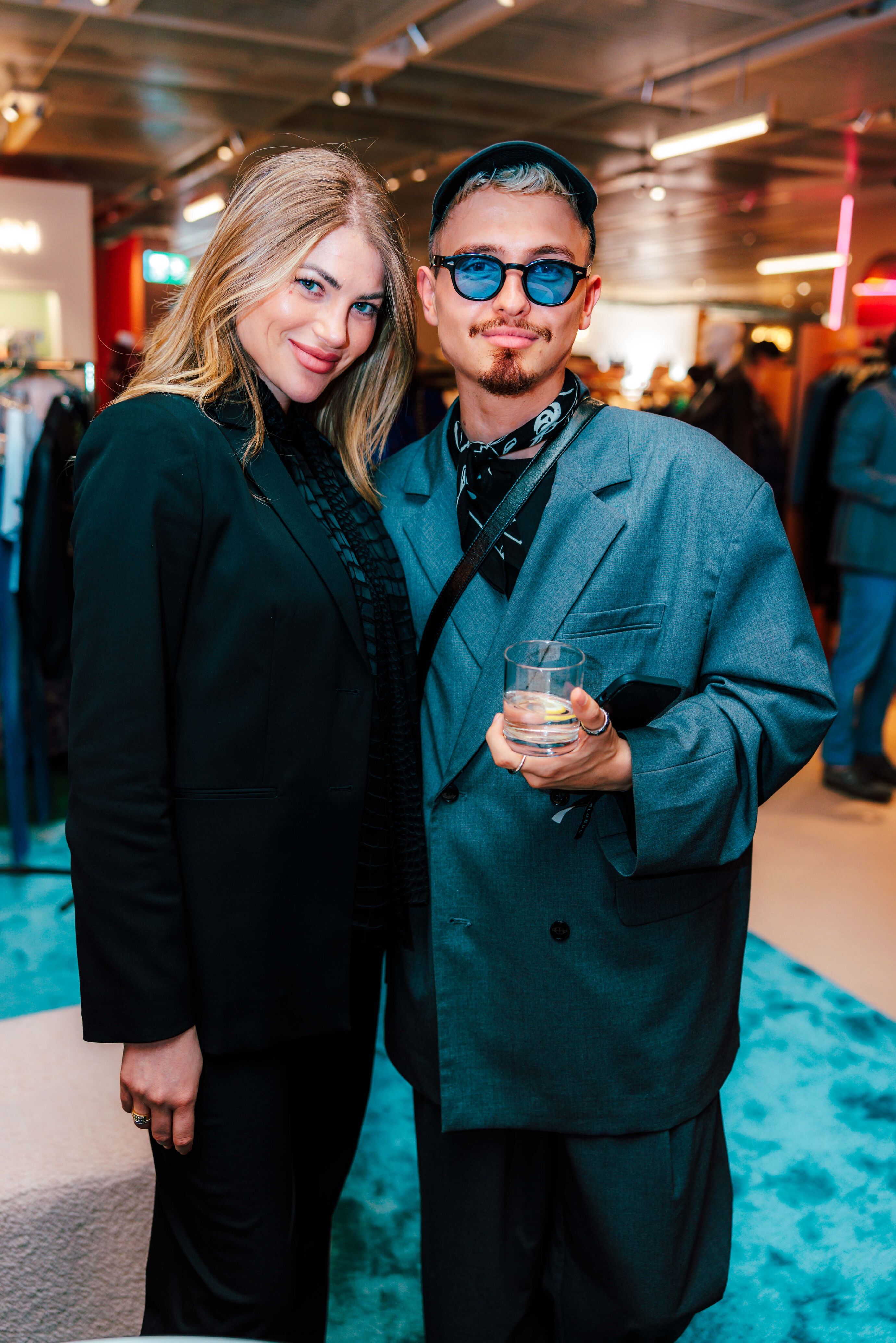 Ein elegantes Paar posiert stilvoll bei der Eröffnung des Globus Womenswear.