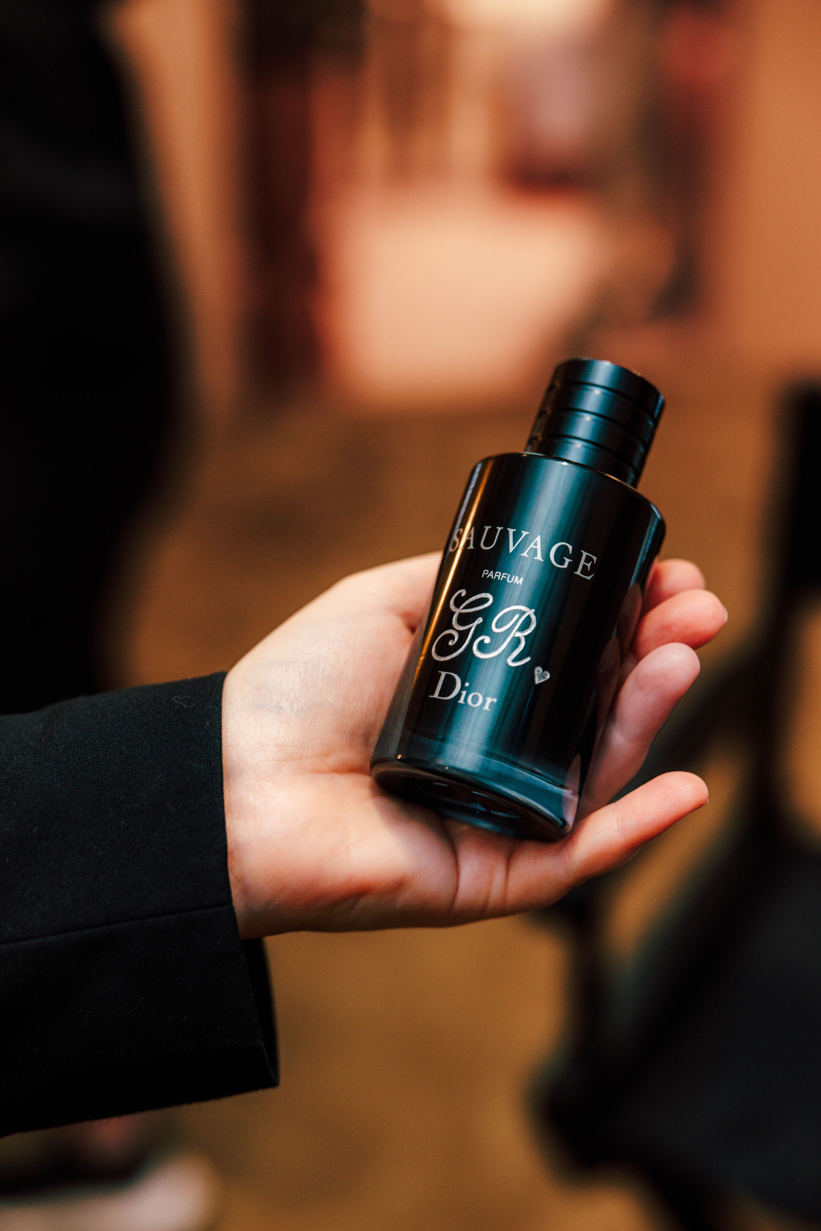 Hand hält Dior Sauvage Flakon beim Globus Opening