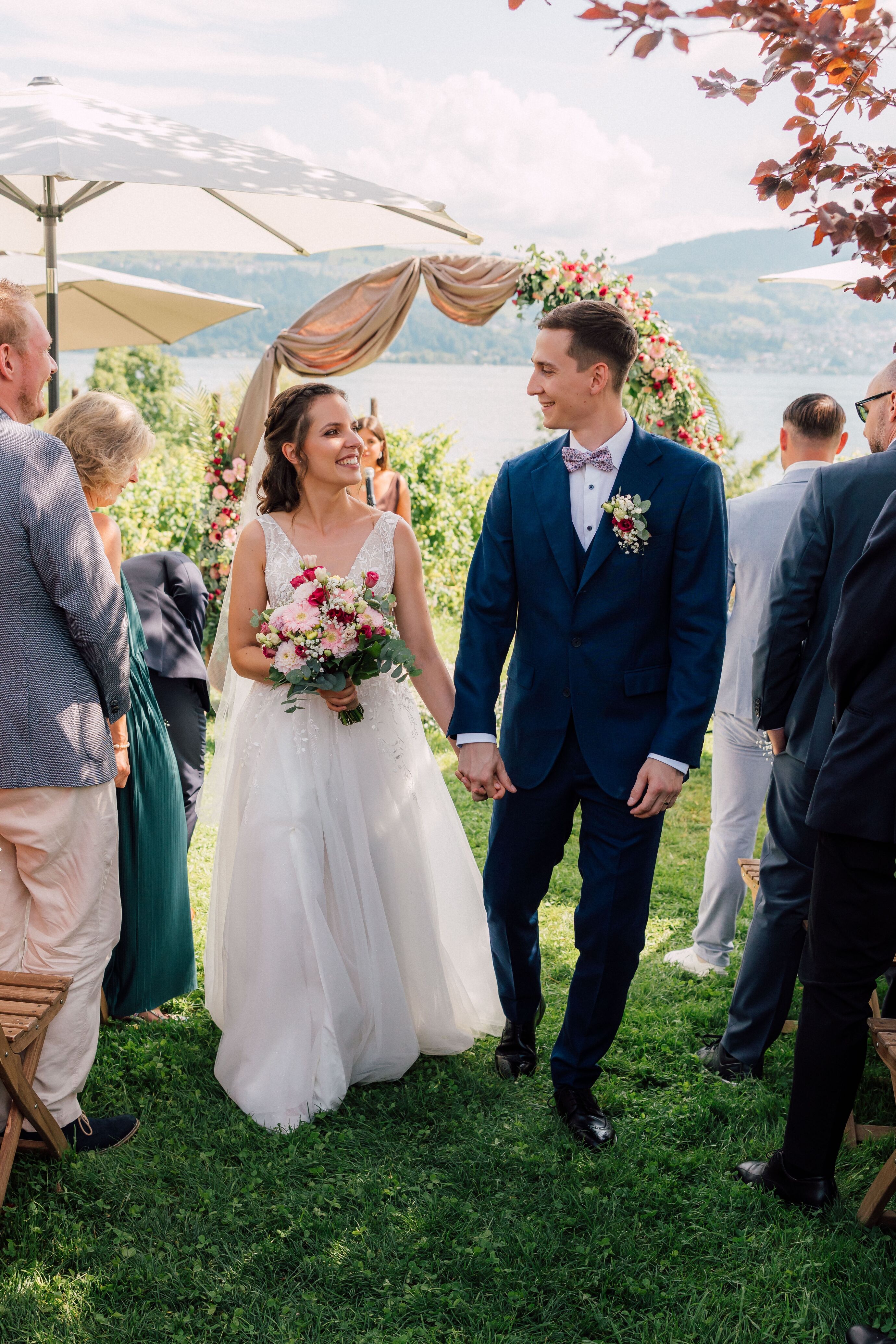 Hochzeitsfotograf Zürich – Brautpaar nach der Trauung unter Traubogen am See