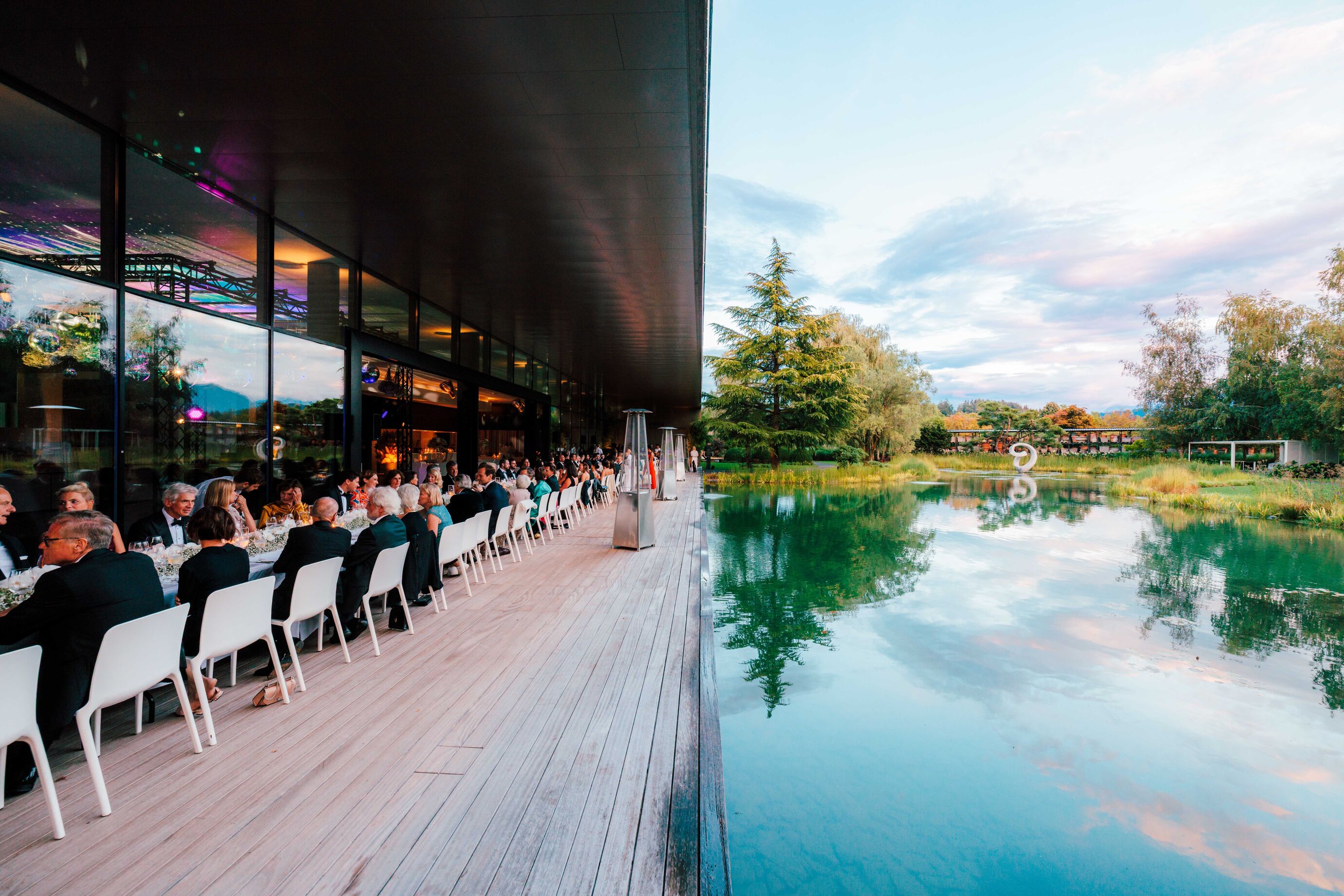 Hochzeitsfeier Zürich – lange Tafel am Abendessen mit Blick auf Pool und Garten