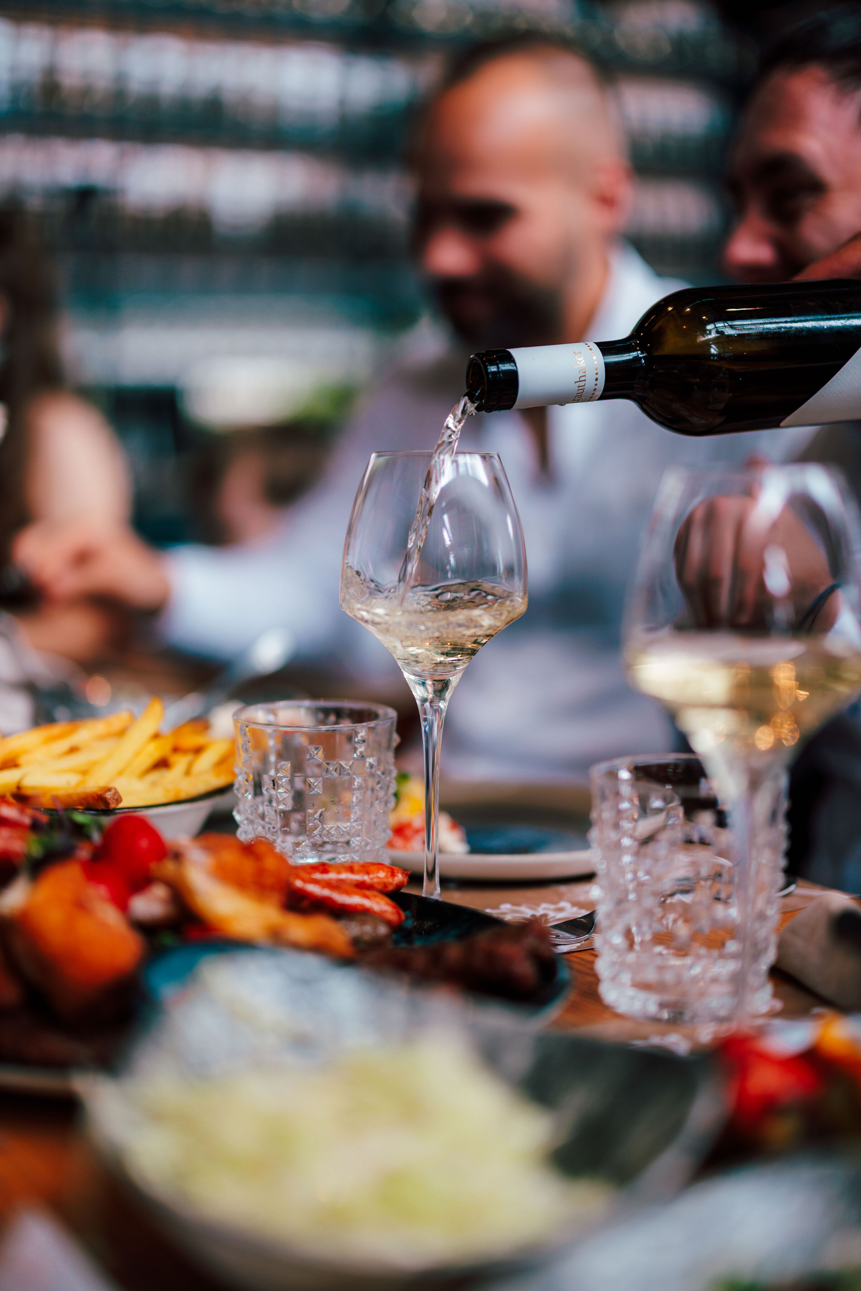 Eventfotograf Zürich Wein wird am Tisch bei Dinner-Event eingeschenkt