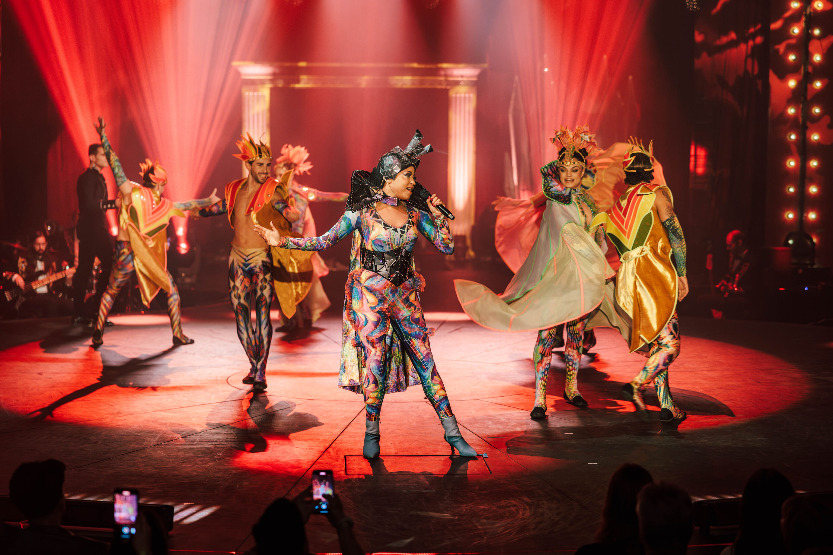 Grosse Tanzgruppe in farbenprächtigen Kostümen auf der Bühne