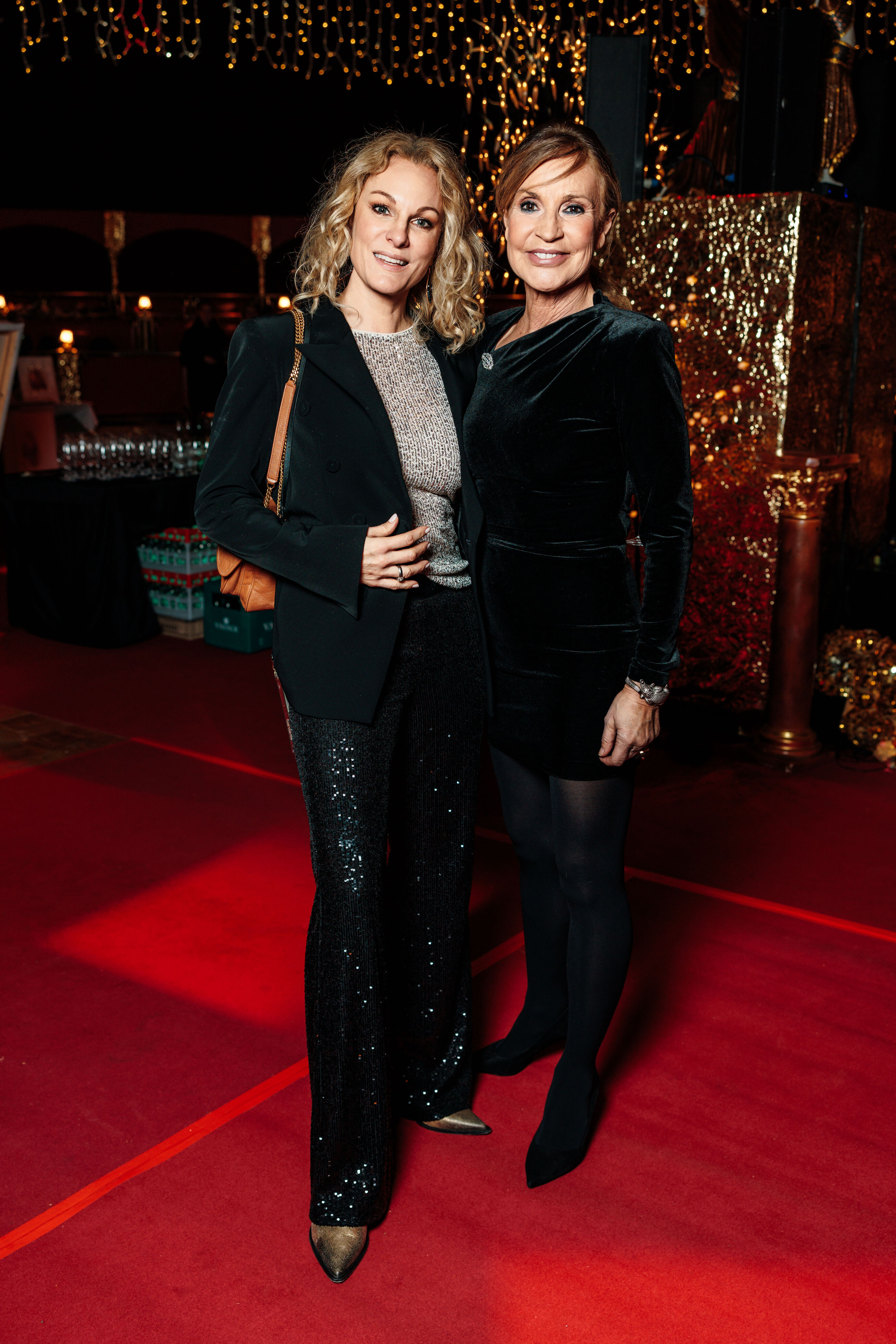 Zwei Frauen in schwarzen Outfits posieren für ein Foto